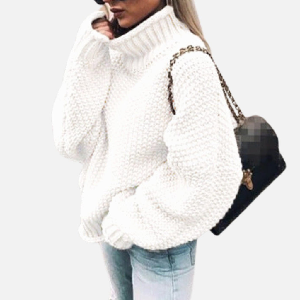 Mujer con jersey oversize de punto grueso y cuello alto en color neutro