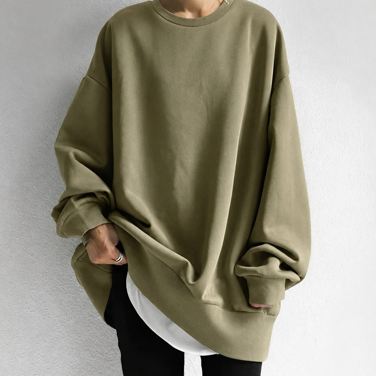 Mujer luciendo jersey túnica oversize con hombros caídos combinado con leggings