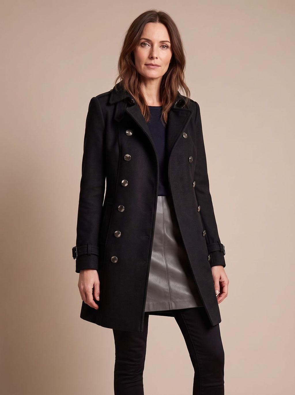 Detalle de la botonadura dorada y solapa del abrigo entallado de invierno para mujer